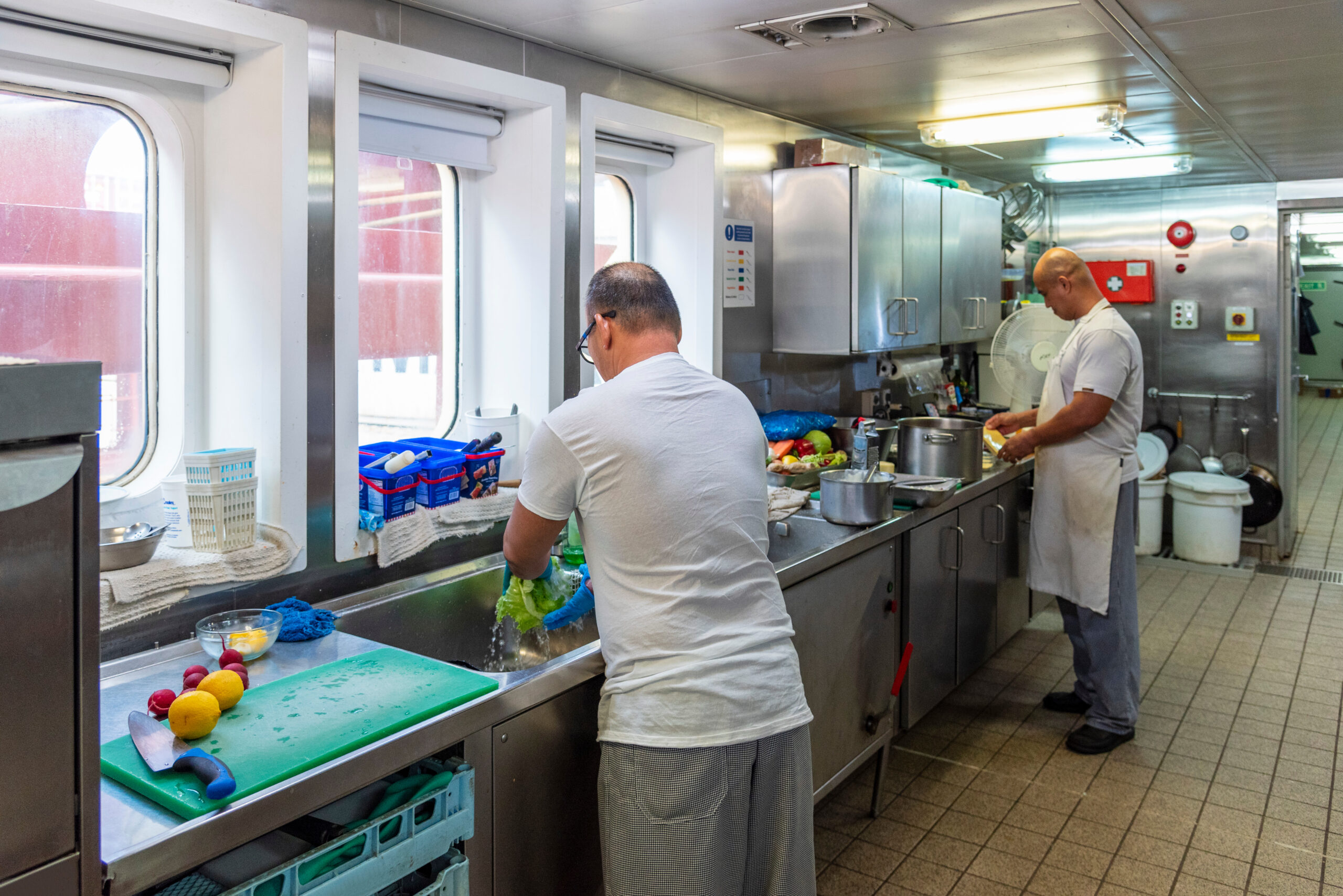 Ship's cooks at work in the galley of a merchant vessel—focused, skilled, and essential to daily life at sea. Ship's cooks at work in the galley of a merchant vessel—focused, skilled, and essential to daily life at sea.